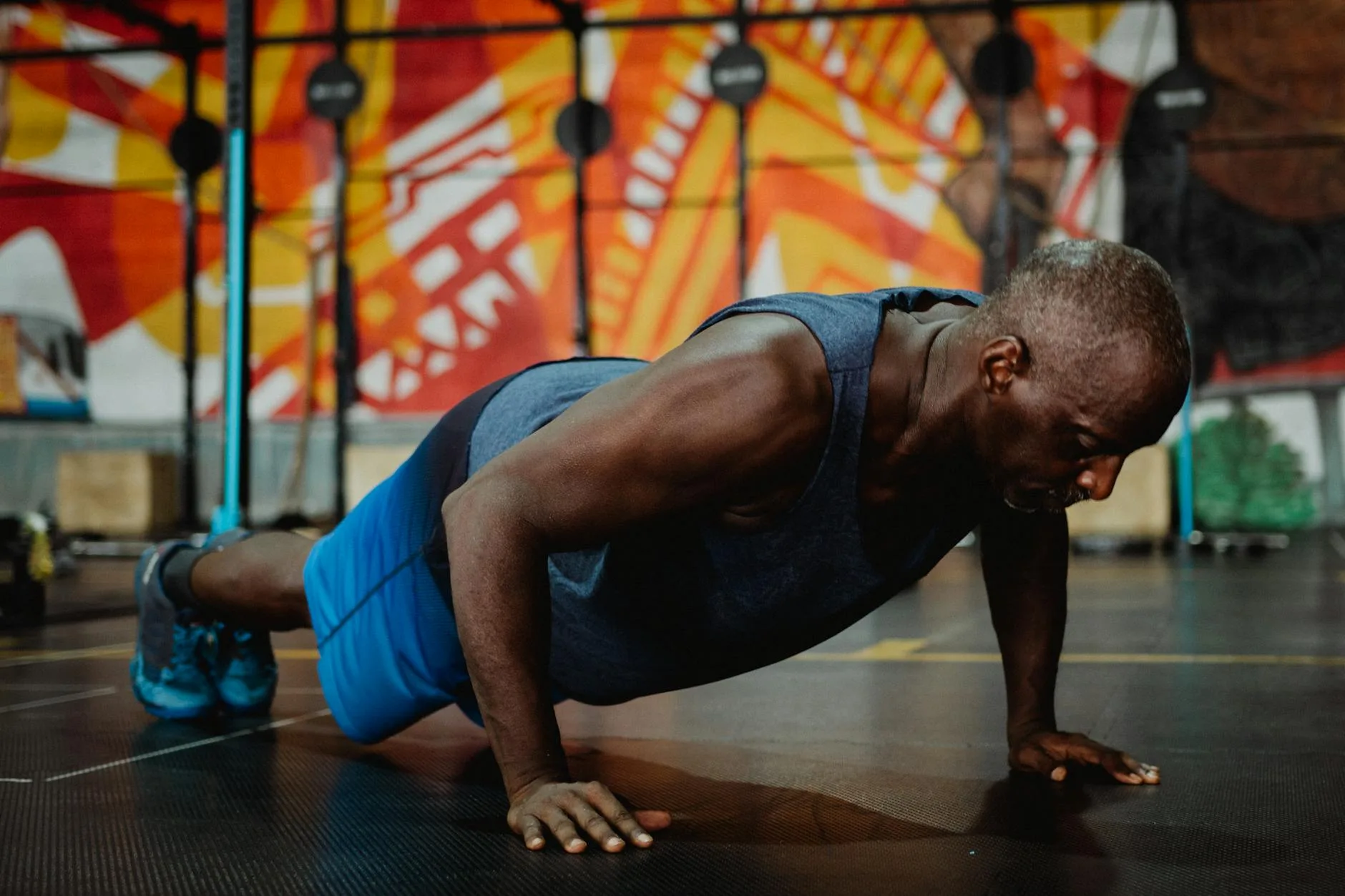 a man in gray tank top doing push ups