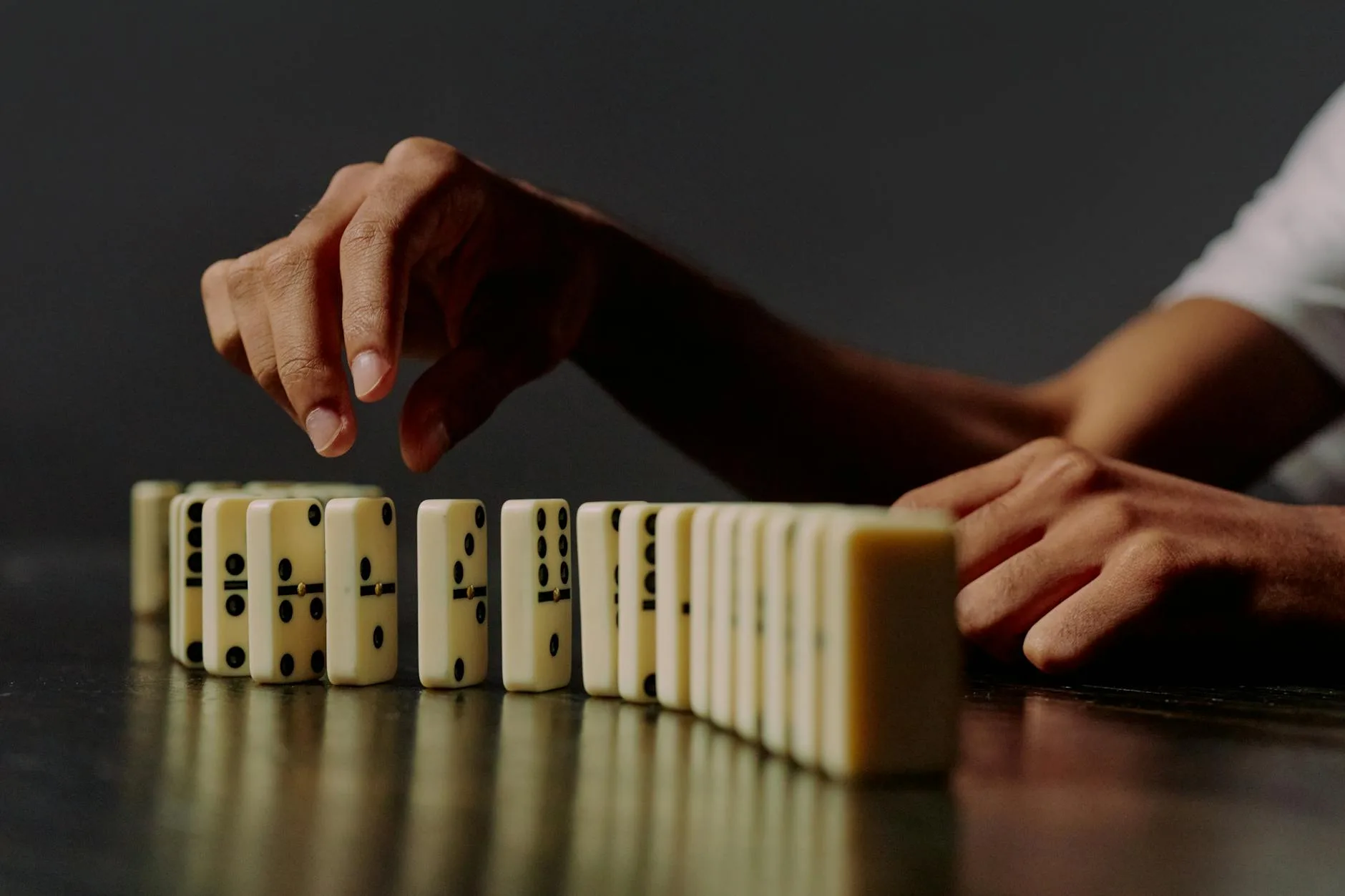 Capítulo 11: El precio de la verdad domino blocks in a row and human hand trying to take one of it