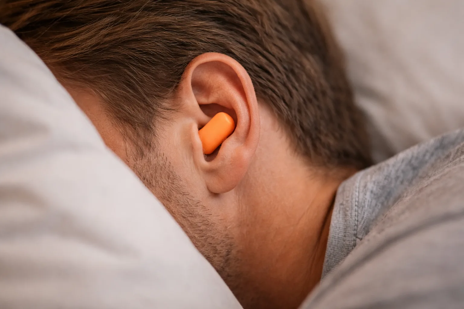 Tapones para dormir colocados en el oído de una persona, mostrando ajuste cómodo para reducir el ruido nocturno