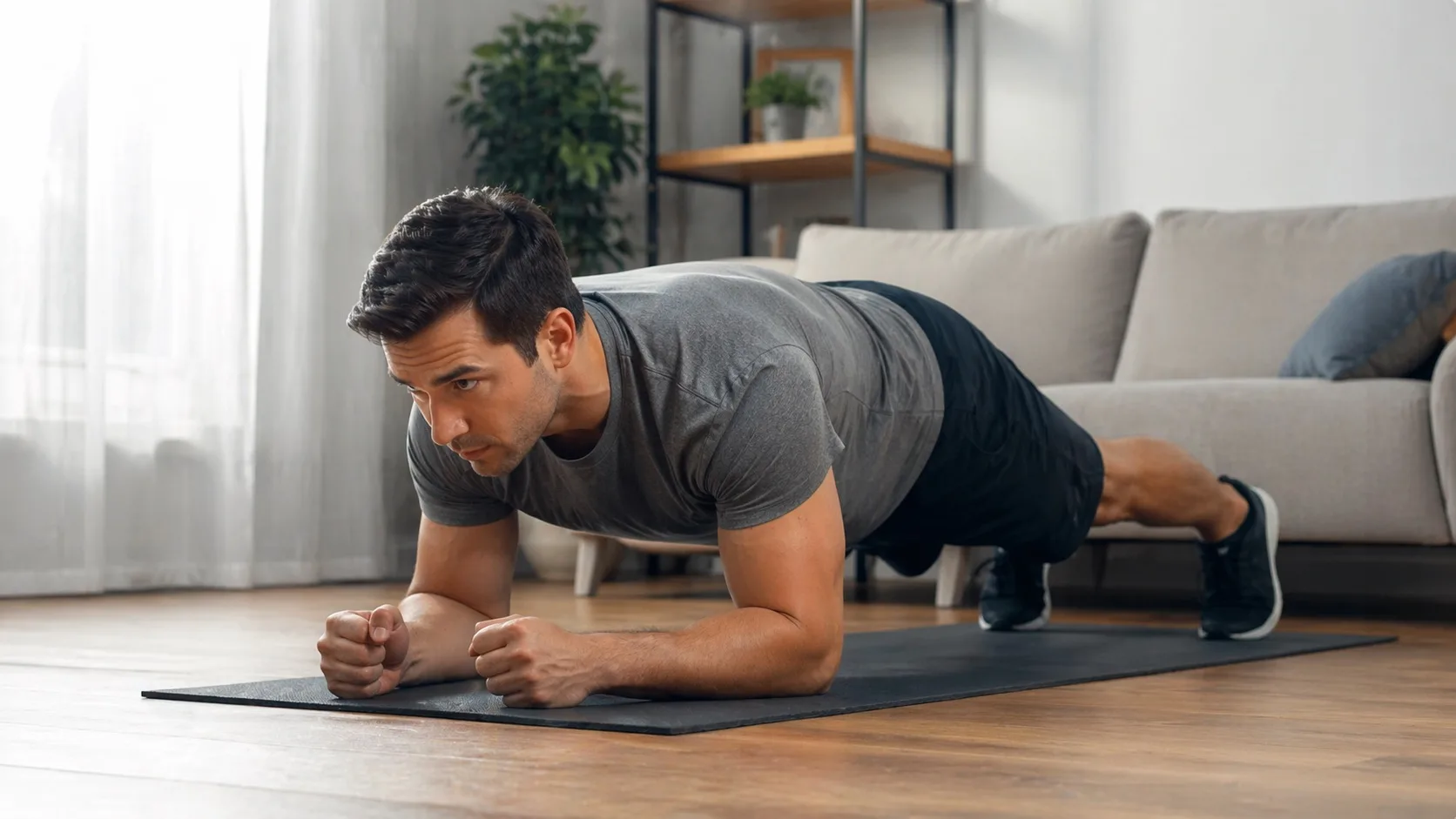 Hombre realizando ejercicios isométricos en casa manteniendo posición de plancha sobre una esterilla
