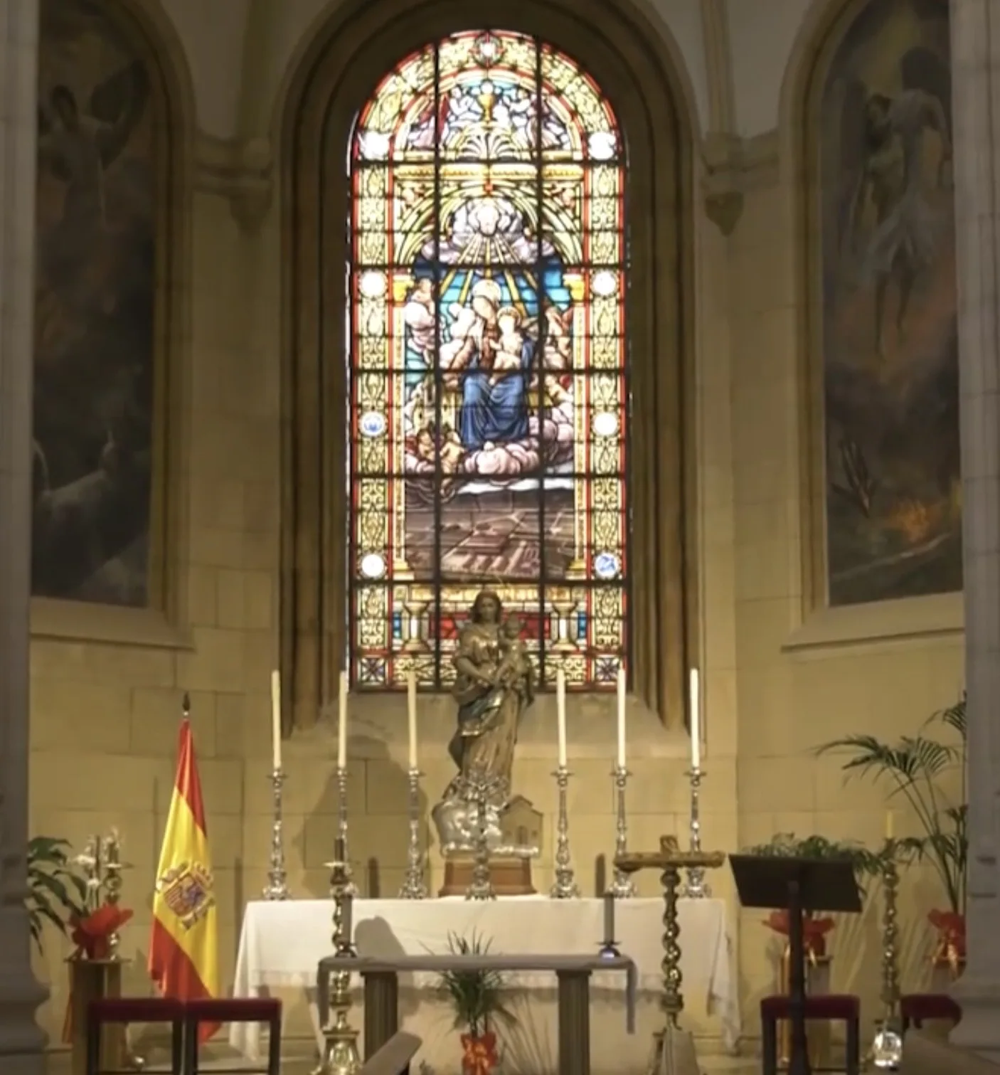En la Capilla de la Virgen de Loreto de la catedral de Albacete, un altar con velas y una imagen mariana se alza ante una vidriera colorida.